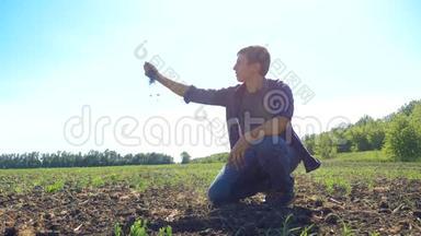 一个农民工人手里握着新鲜的土壤。 慢动作视频。 人的地面泥土保持泥土春天的象征